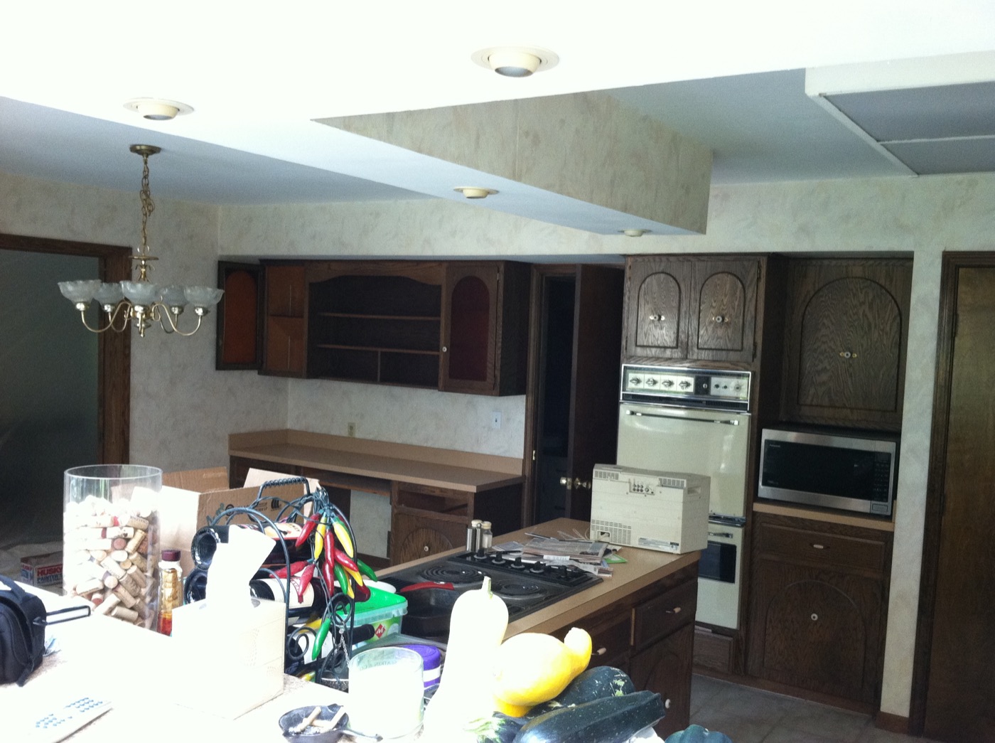 The same kitchen before the remodel, with dark wood cabinets and a dropped soffit